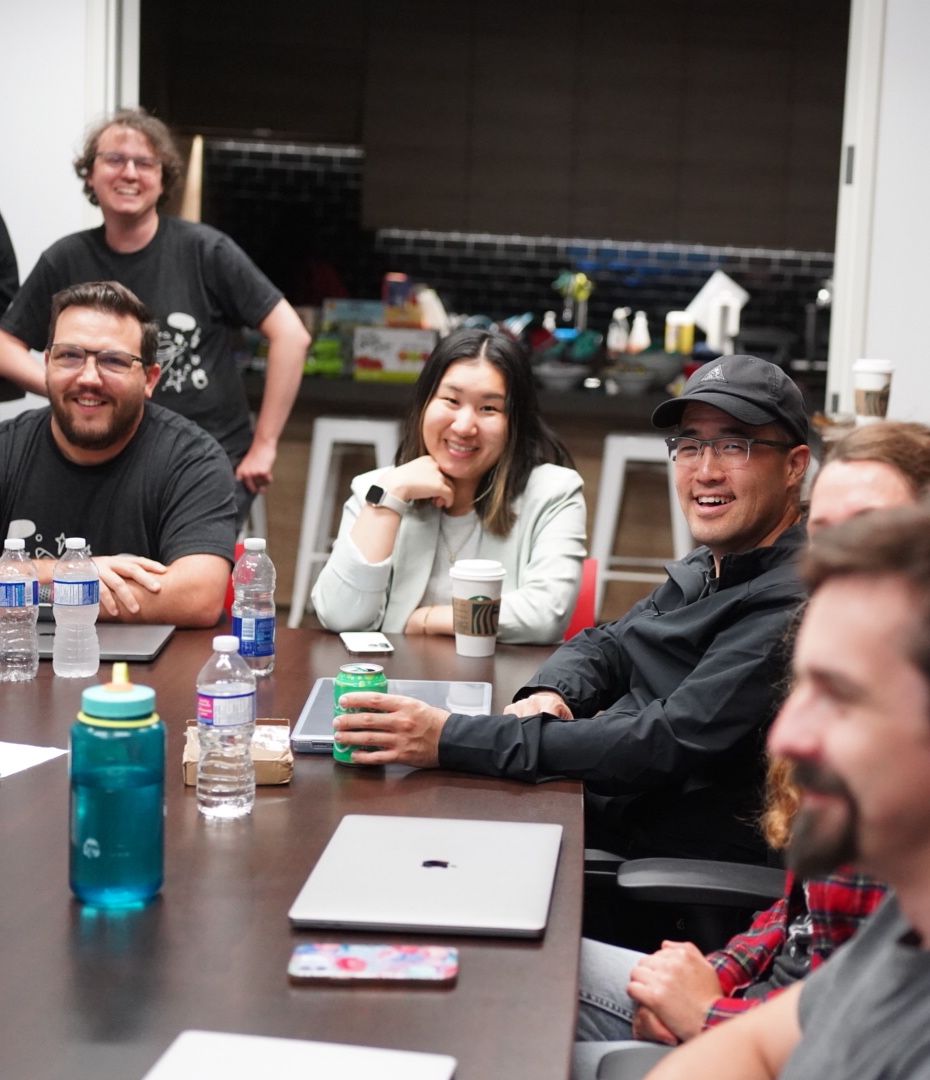 About 5 people from the team seated at a conference room table.